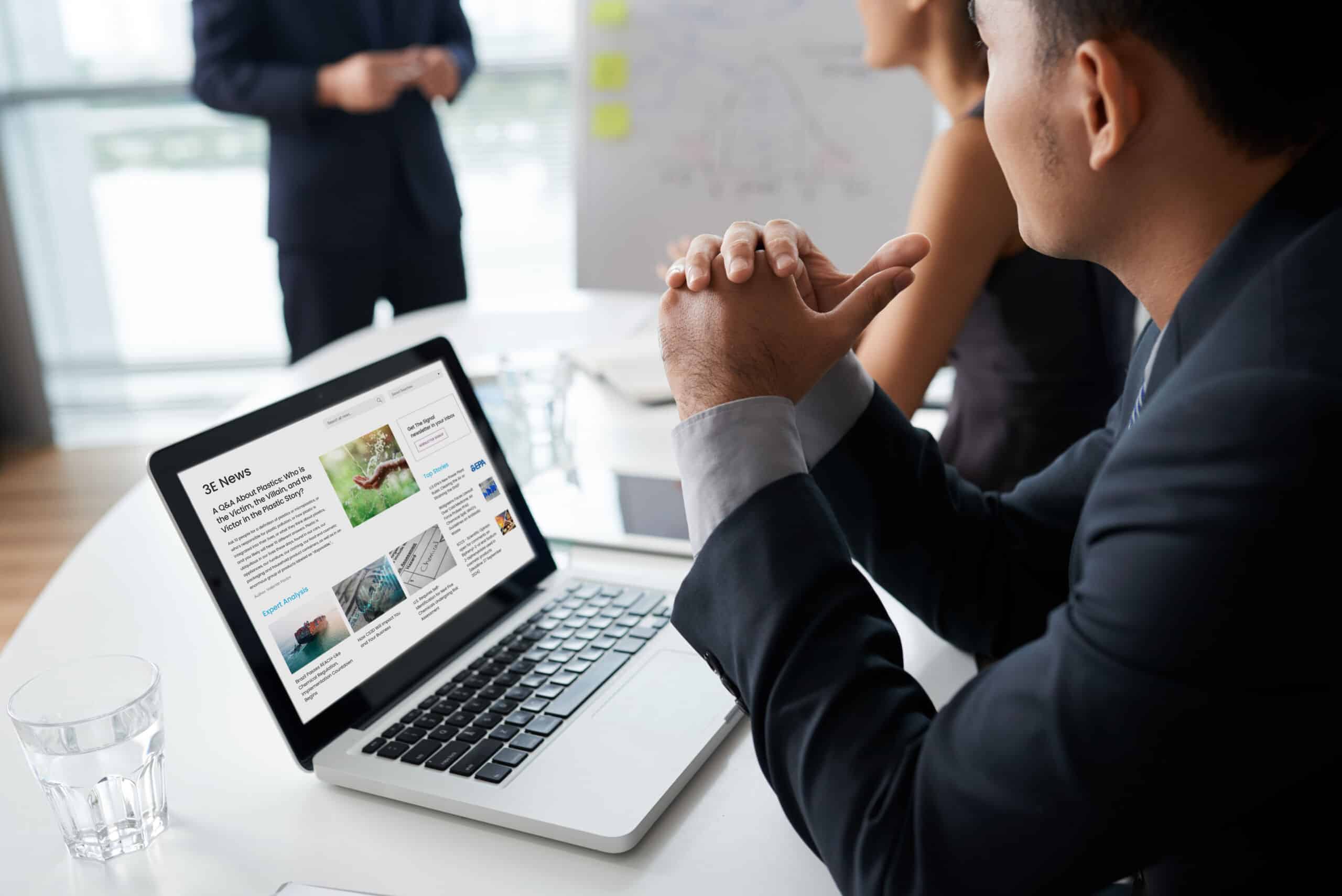 Professionnel analysant des données de conformité PFAS sur un ordinateur portable lors d'une réunion.